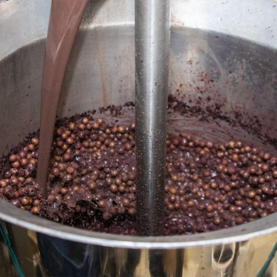 Close-up of a metal tank with liquid being poured over dark açai - Prime Green Trade