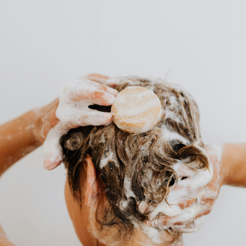 Women applying a shampoo with babassu oil
